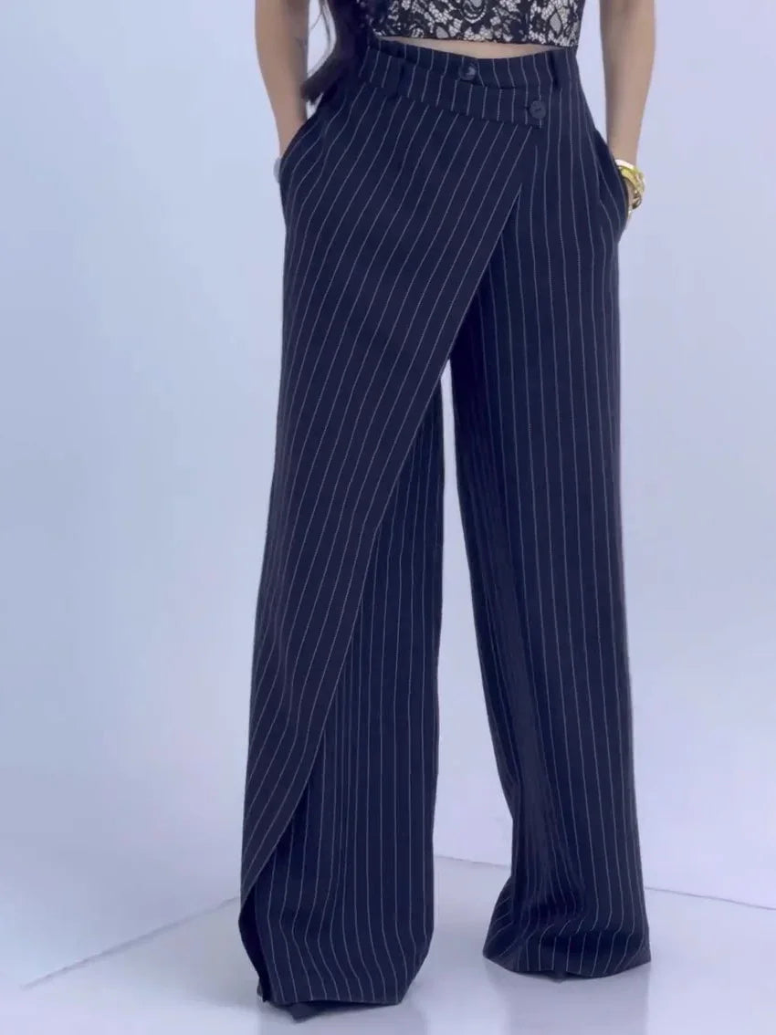 Woman wearing black pinstripe wide-leg pants with button detail and pockets
