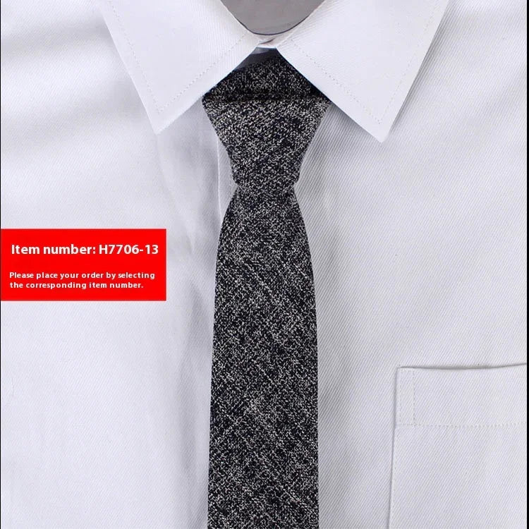 Close-up of men's grey textured necktie on white dress shirt with pointed collar