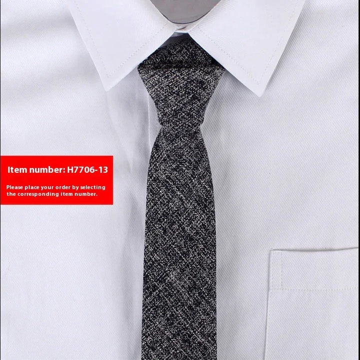 Close-up of men's grey textured necktie on white dress shirt with pointed collar