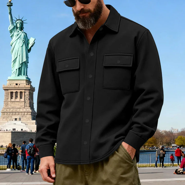 Man wearing black button shirt and sunglasses near Statue of Liberty on clear day
