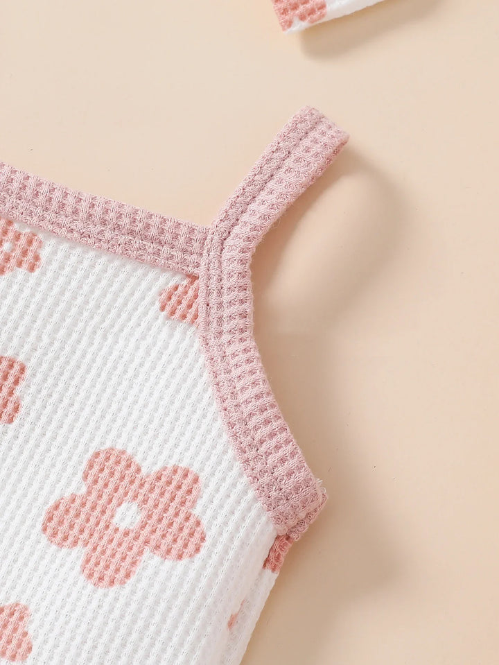 Close-up of white knit fabric tank top with pink floral pattern and pink ribbed straps