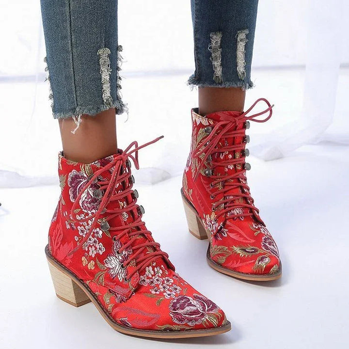 Red floral embroidered lace-up ankle boots with block heels and distressed blue jeans