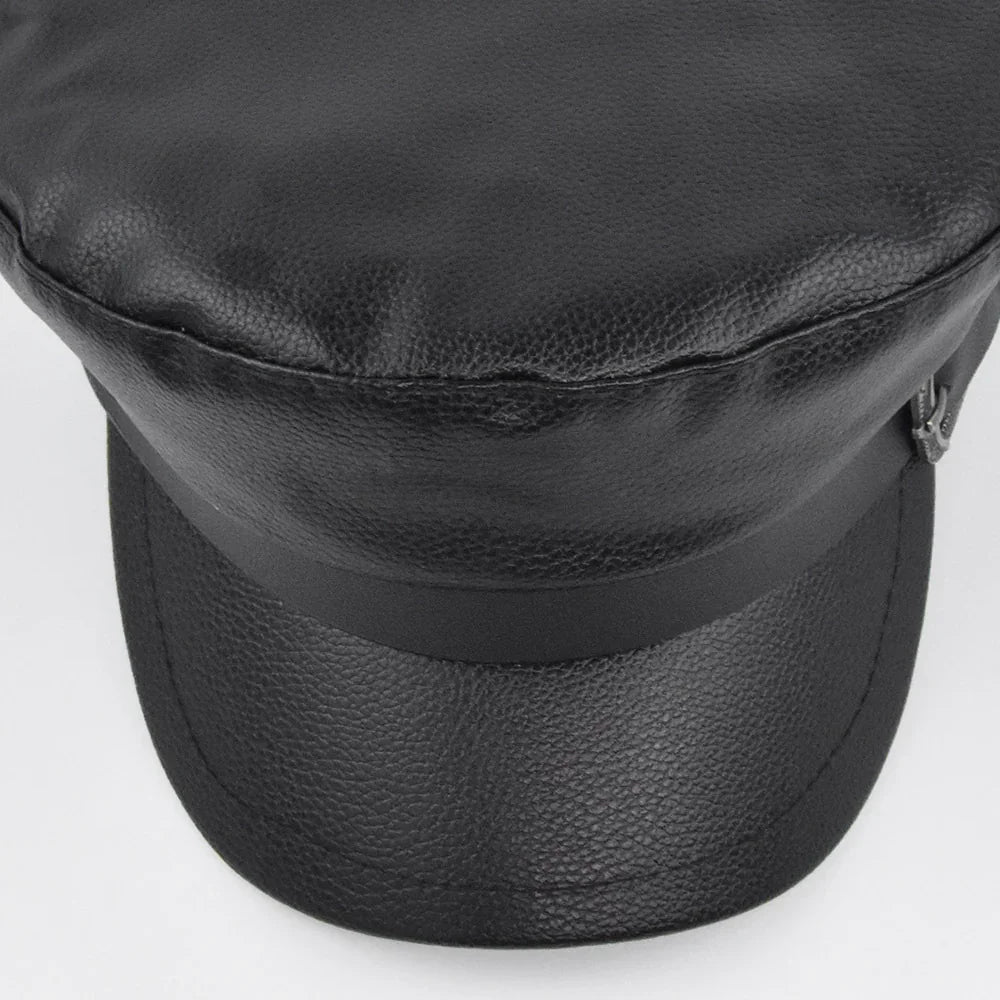 Black faux leather baker boy cap with a shiny strap detail on a white background