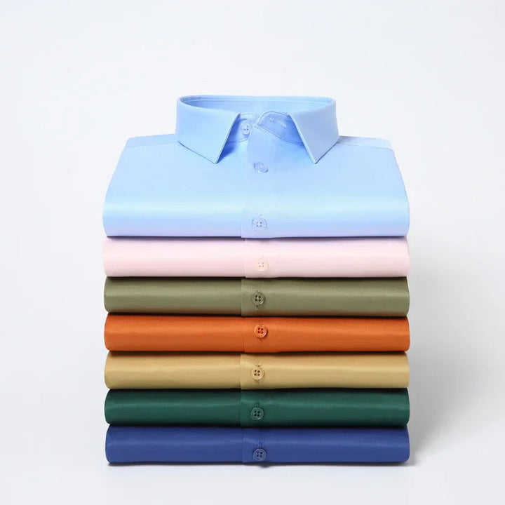 Stack of neatly folded men's dress shirts in pastel and earthy colors including blue, pink, olive, orange, beige, green, and navy
