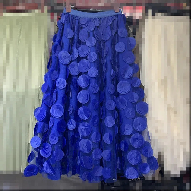Blue skirt with layered circular fabric appliques hanging on a rack in a clothing store