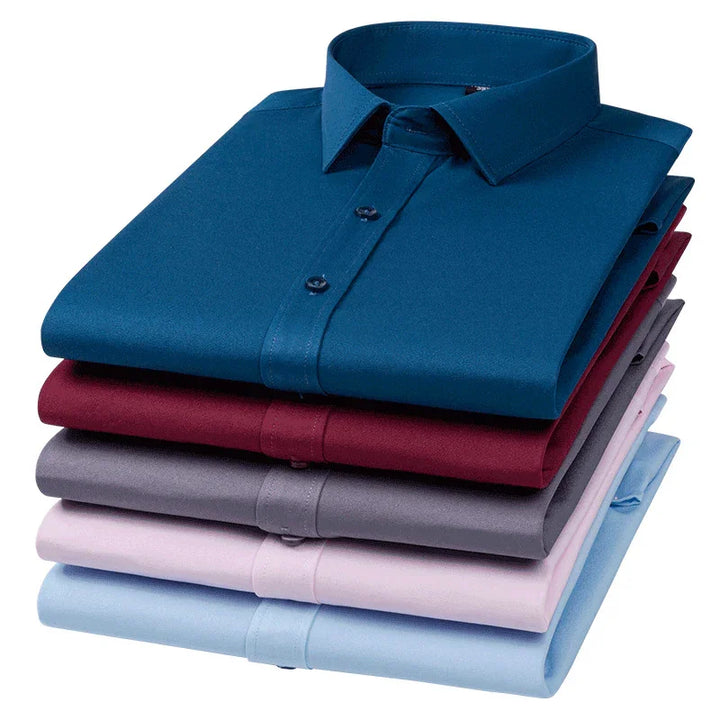 Stack of five neatly folded men's dress shirts in blue, burgundy, gray, pink, and light blue colors