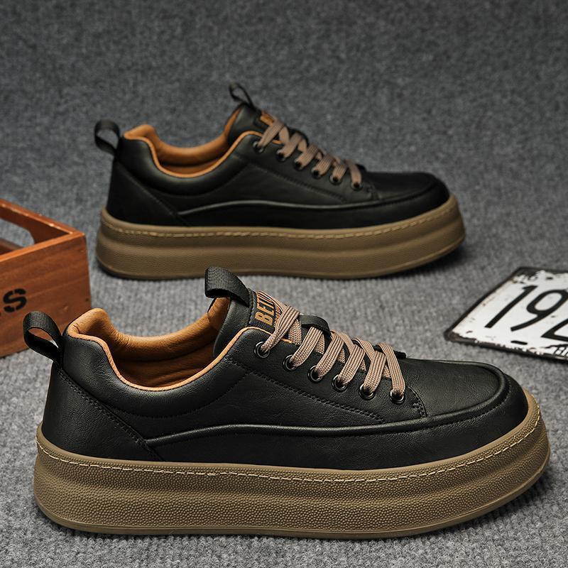 Black casual sneakers with brown thick soles and laces on gray carpet background