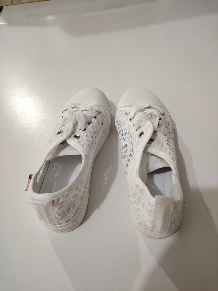 Pair of white lace casual sneakers with rubber toe caps and laces on a white surface