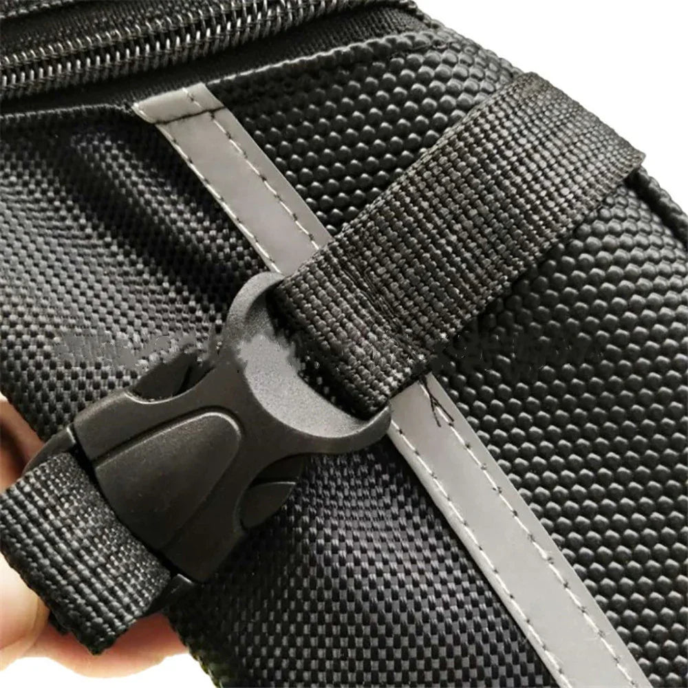 Close-up of black textured bag with zipper, reflective strip, and plastic buckle strap