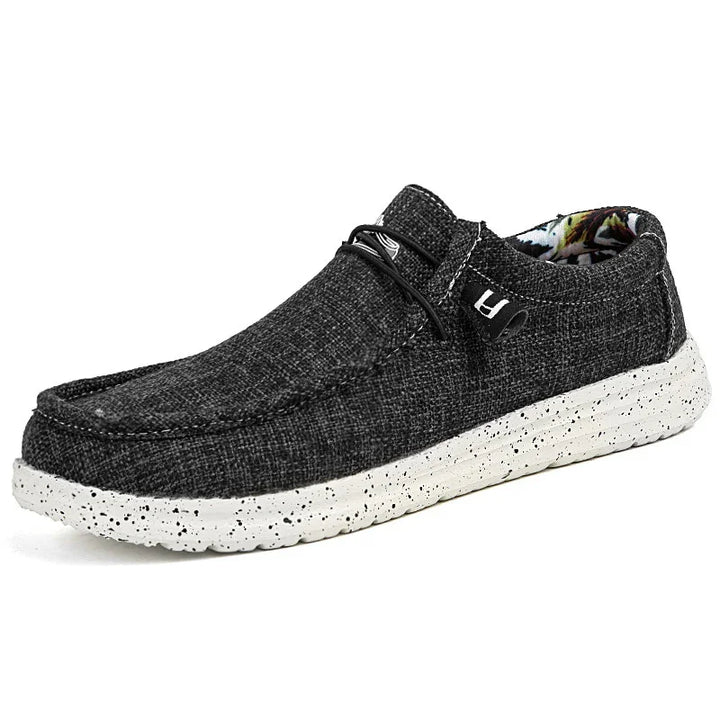 Black textured casual slip-on shoe with white speckled sole and floral inner lining