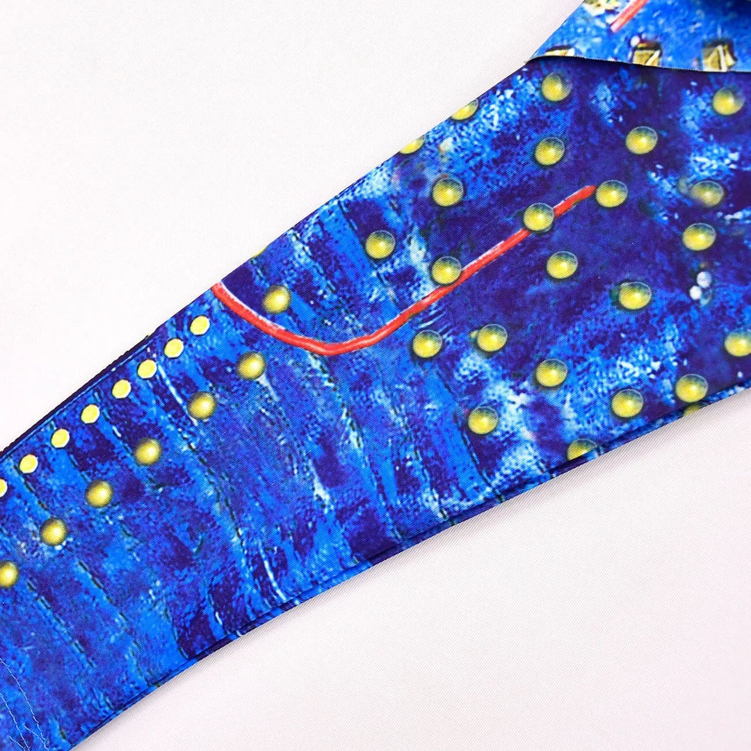 Close-up of blue fabric with yellow dots and red line pattern on white background