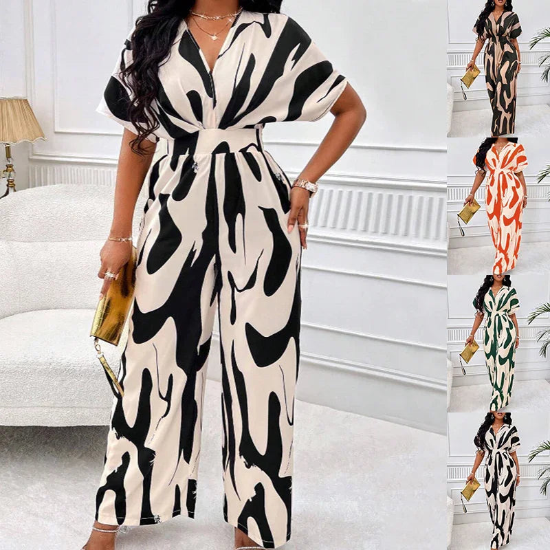 Woman wearing black and white abstract print wide-leg jumpsuit with short sleeves in a modern white room