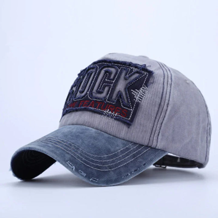 Gray and blue distressed baseball cap with patched text reading 'ROCK' and decorative stitching