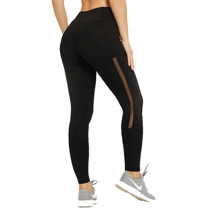 Woman in black high-waist leggings with mesh panels and side pockets, grey sneakers