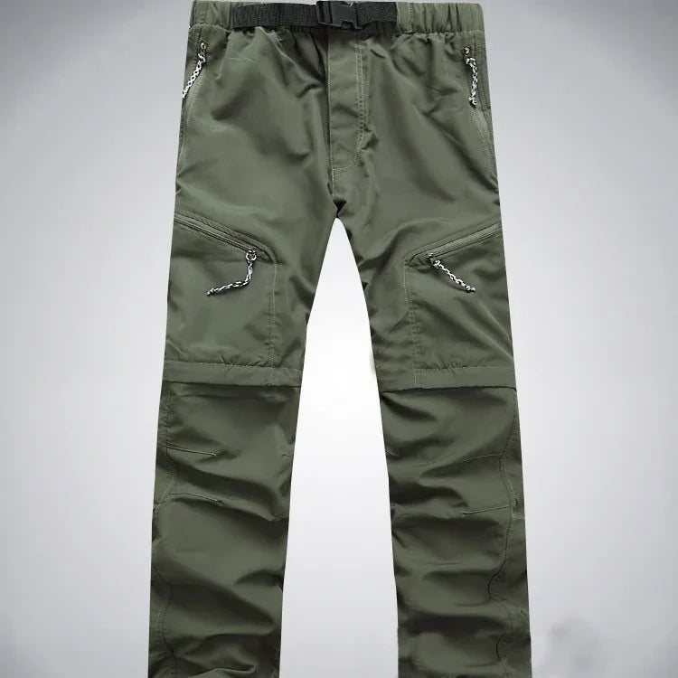 Green outdoor hiking pants with multiple zippered pockets and integrated belt on gray background