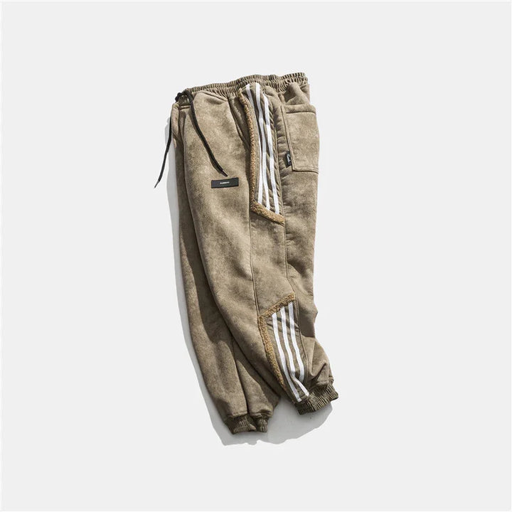 Beige fleece jogger pants with elastic cuffs and white stripe details, laid flat on white background