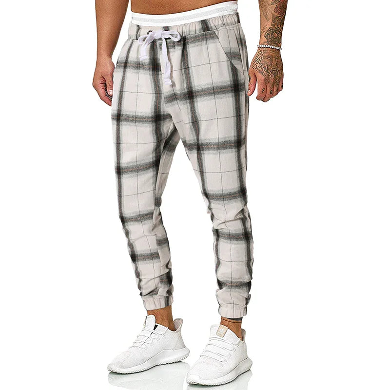 man wearing white and gray plaid jogger pants with white drawstring and white sneakers