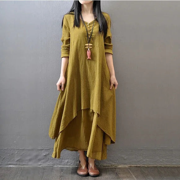 Woman wearing layered olive green long-sleeve cotton dress with asymmetrical hem and brown shoes