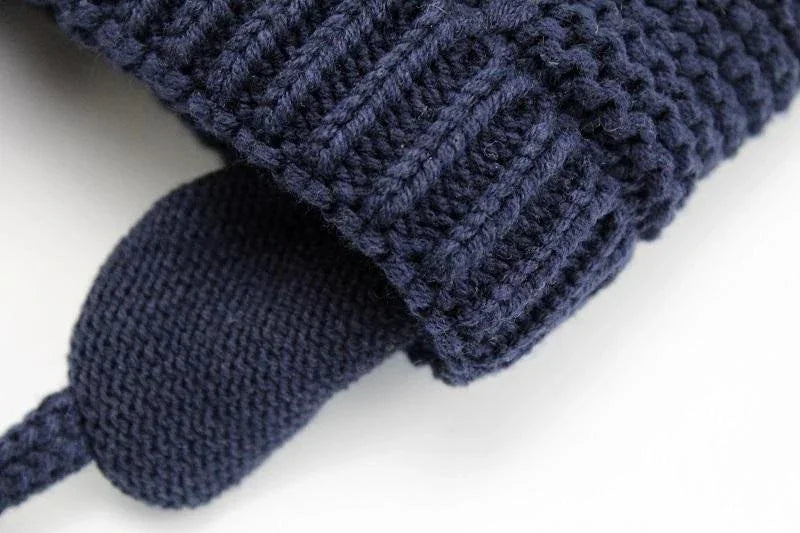 Close-up of navy blue knitted fabric with ribbed cuff and textured knit pattern