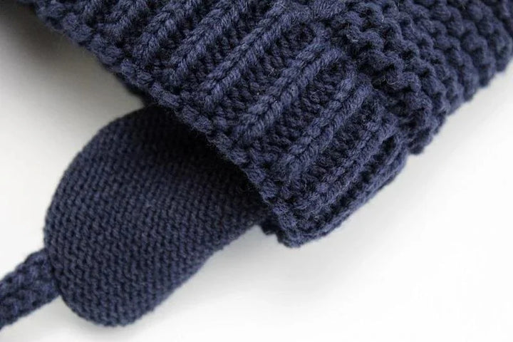 Close-up of navy blue knitted fabric with ribbed cuff and textured knit pattern
