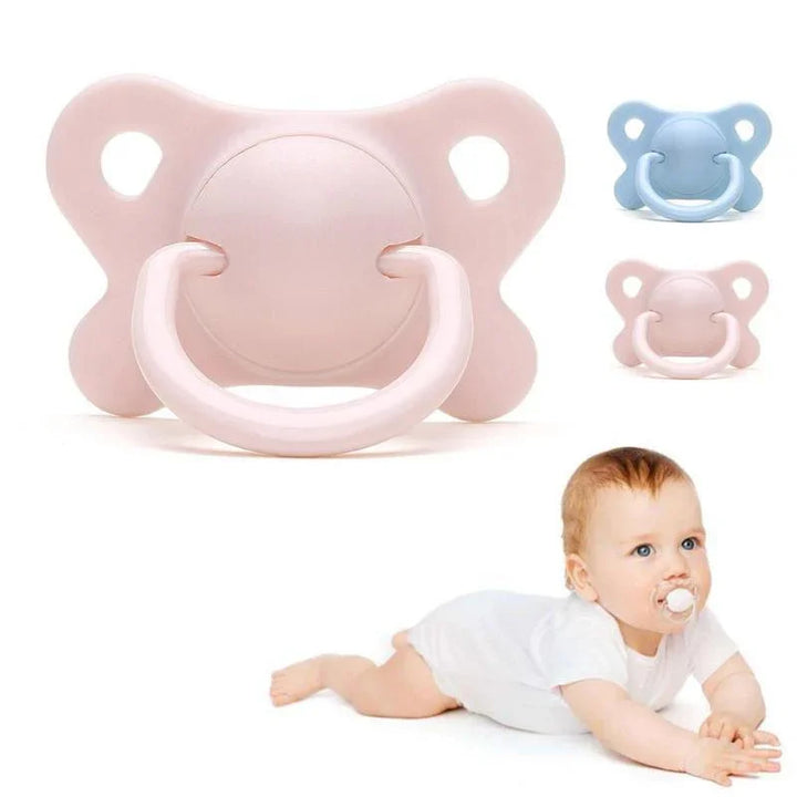 Pink and blue baby pacifiers with a baby in white lying down using a pacifier