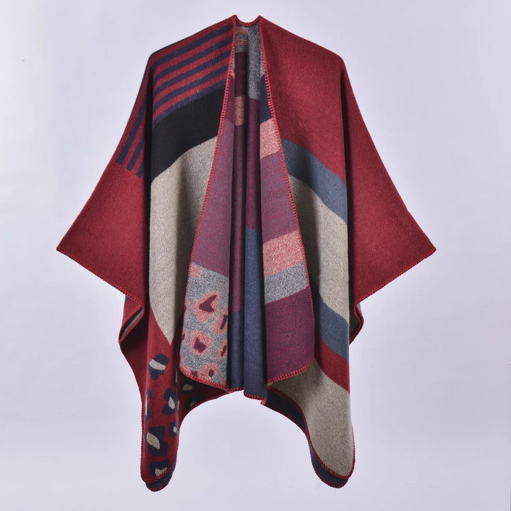 Red and navy poncho with geometric and leopard patterns, soft knit fabric on plain background