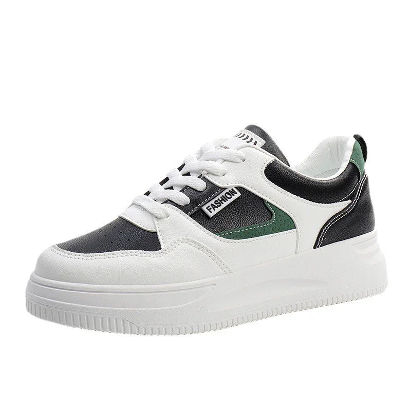 White and black fashion sneaker with green accents and thick sole