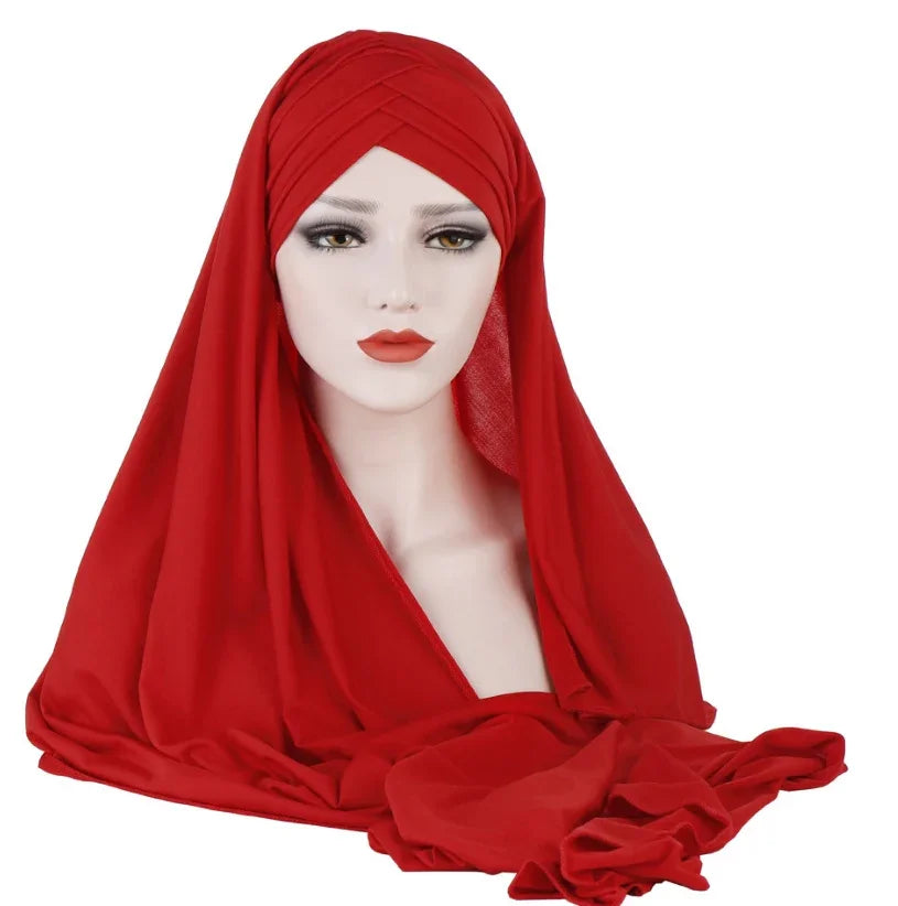 Mannequin head wearing a bright red pleated turban hijab with smooth fabric drape