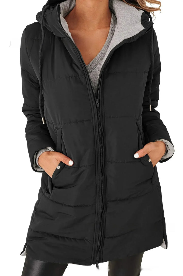Woman wearing black quilted hooded winter coat with front zipper and pockets