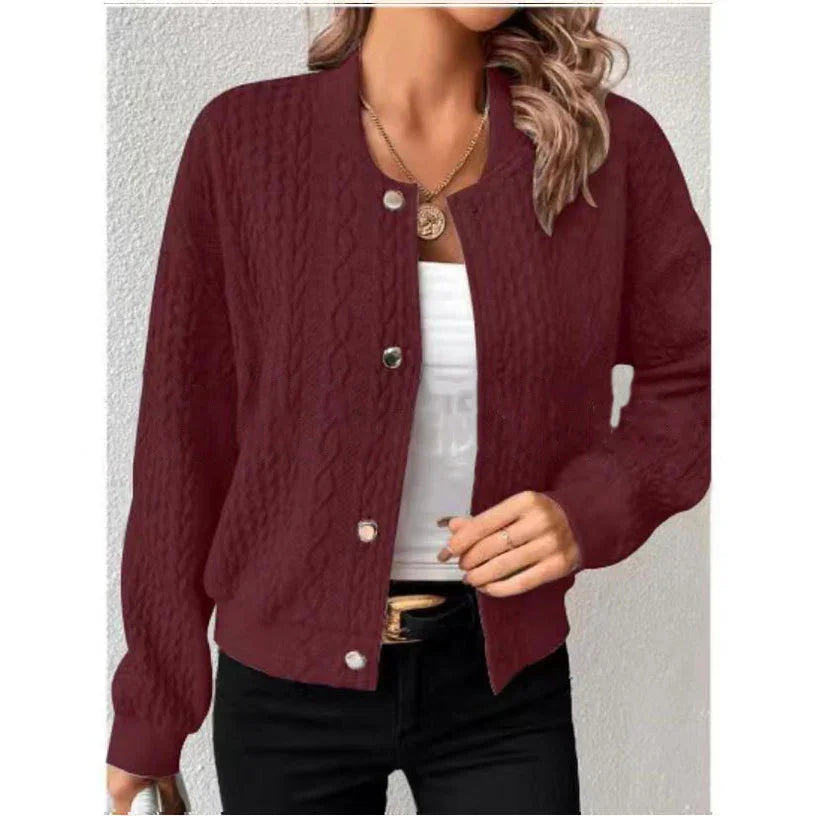 Woman wearing maroon cable knit button-up cardigan with white top and black pants, gold necklace