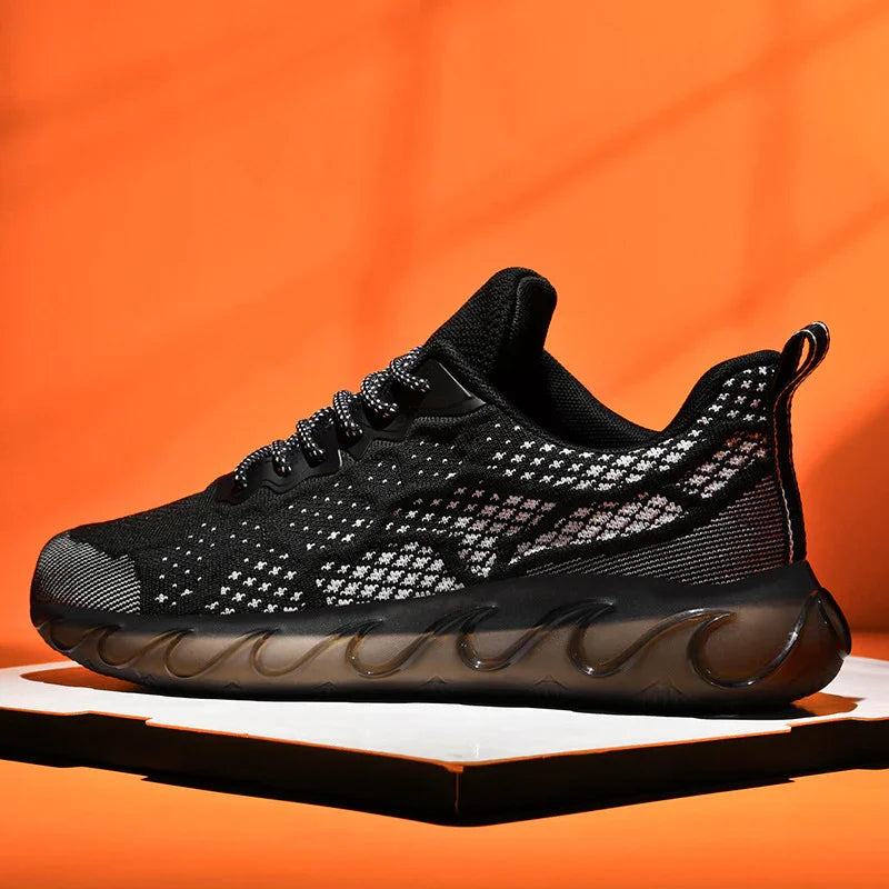 Modern black knit athletic shoe with patterned upper and translucent wavy sole on orange background