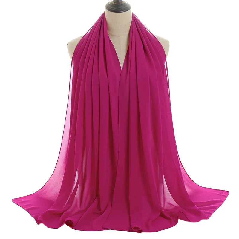 Bright fuchsia pink sheer chiffon scarf displayed on mannequin with flowing draped fabric