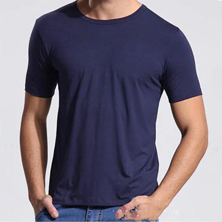 Man wearing plain navy blue crew neck short-sleeve t-shirt with hands in jeans pockets