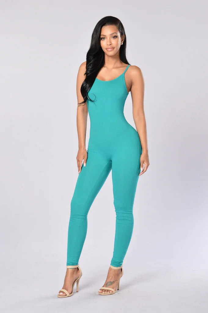 Woman modeling teal sleeveless jumpsuit with scoop neck and nude heels on light background