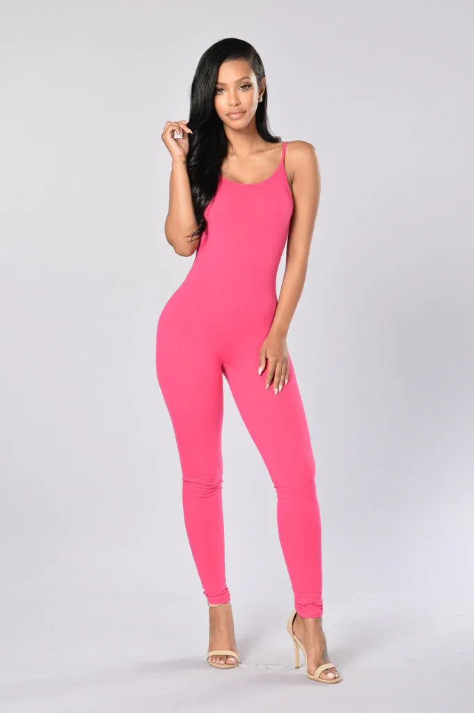 Woman modeling pink sleeveless jumpsuit with spaghetti straps and beige heels, studio background