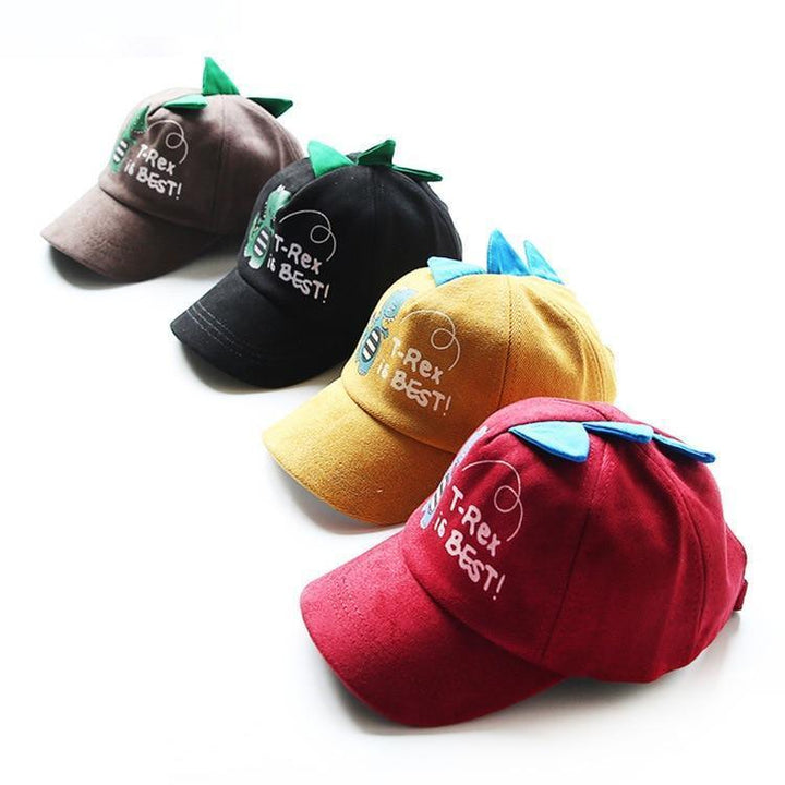 Four colorful kids caps with dinosaur spikes, each embroidered with "T-Rex is Best!" in brown, black, yellow, and red colors
