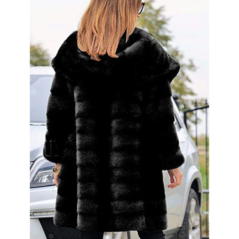 Woman with blonde hair wearing a black fur coat standing outdoors near a white car