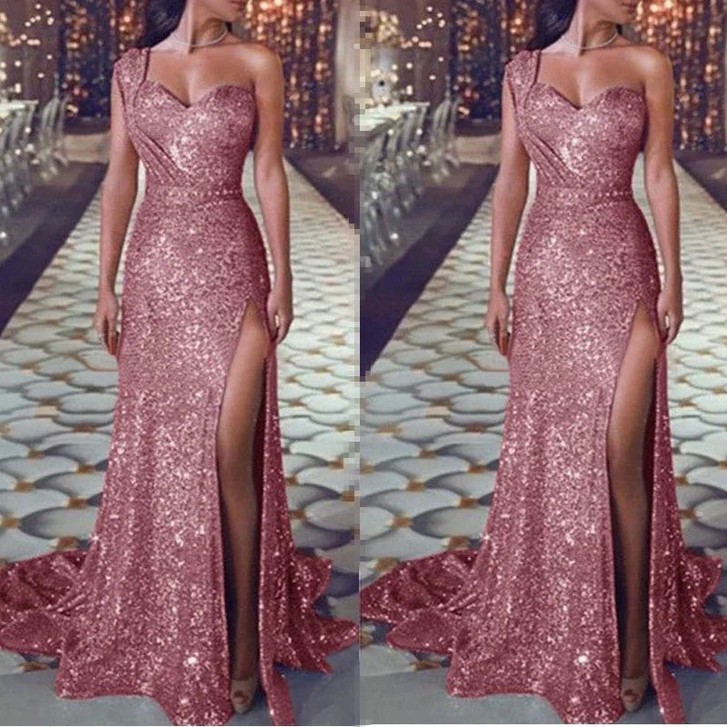 Woman wearing a sparkling rose gold sequin evening gown with thigh-high slit and one-shoulder design on elegant floor