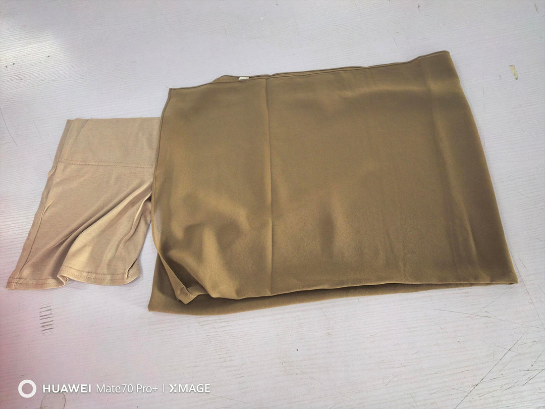 Folded beige and tan compression or shaping garments on white surface