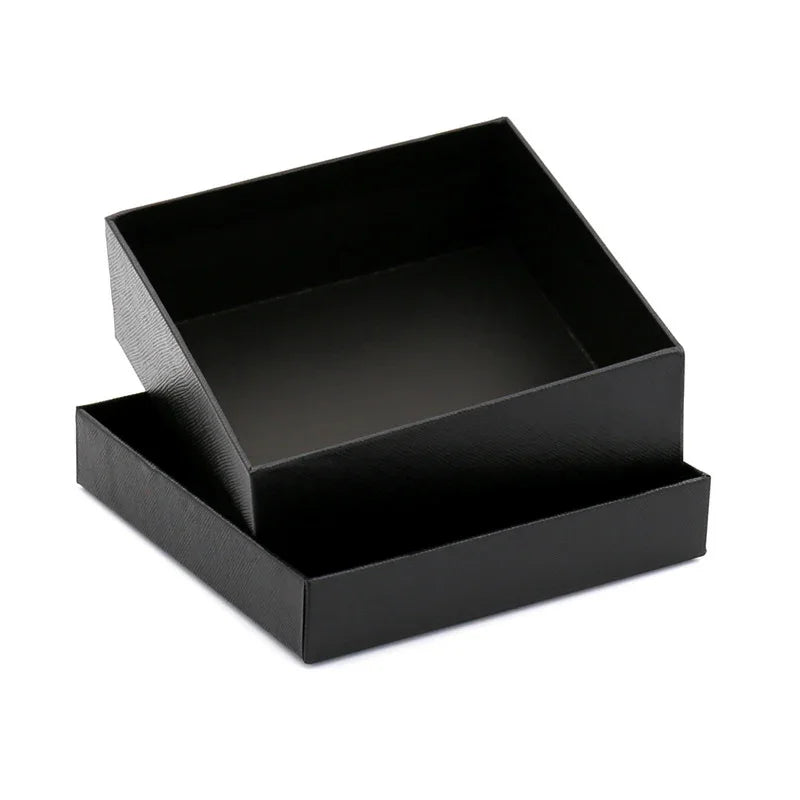 Open black textured square gift box with detached lid on white background