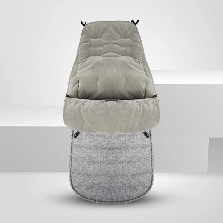 grey cushioned baby stroller footmuff with soft, quilted fabric and adjustable openings