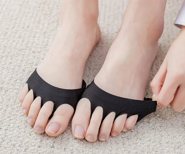 Feet wearing black open-toe socks on a beige carpet