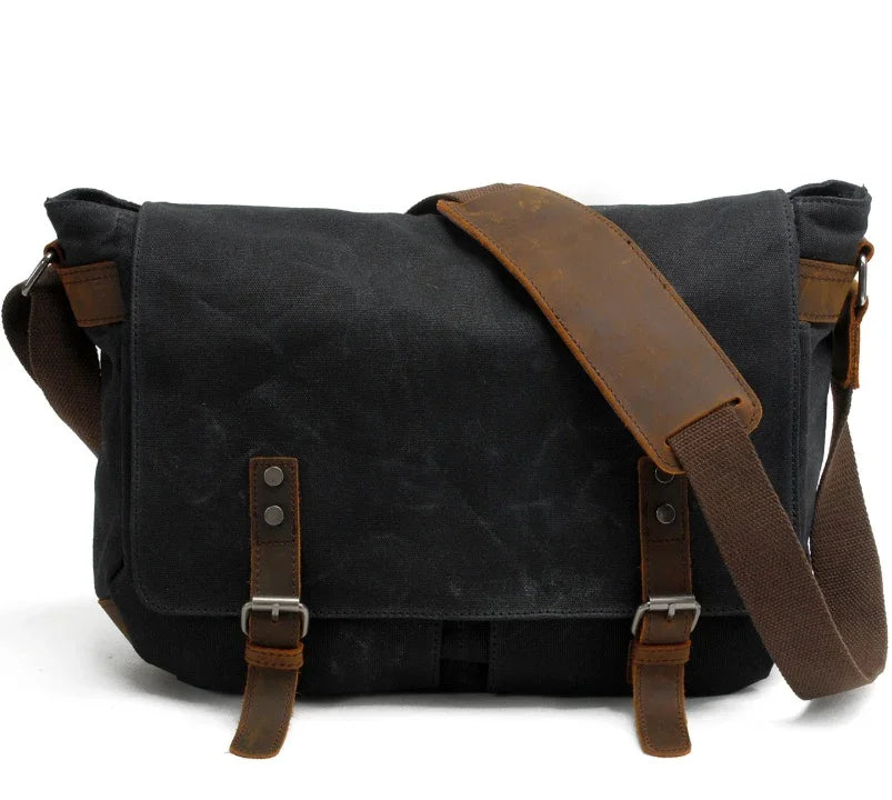 Black canvas messenger bag with brown leather straps and adjustable shoulder strap