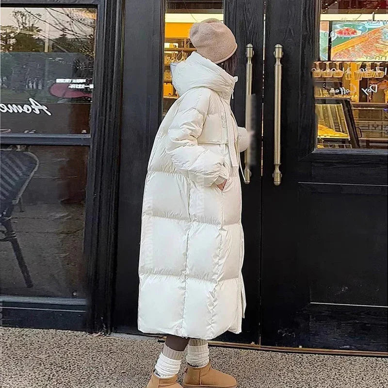 Person wearing long white puffer coat and beige beanie opening black door outside cafe