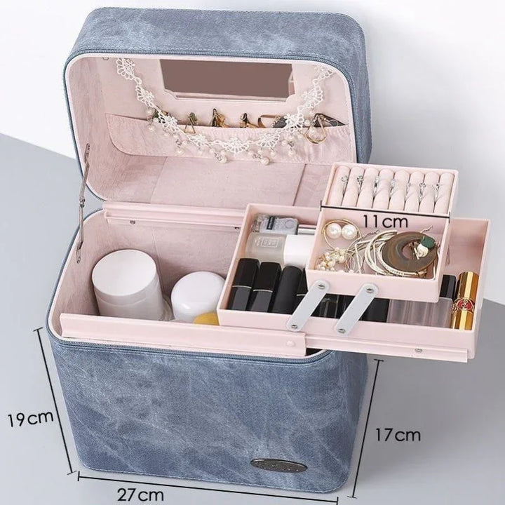 Blue fabric makeup and jewelry organizer box with multiple compartments, mirror, and various cosmetics