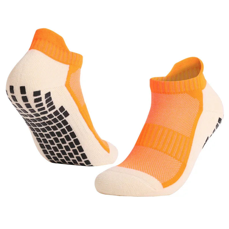 Pair of orange and white ankle socks with black non-slip grip dots on soles