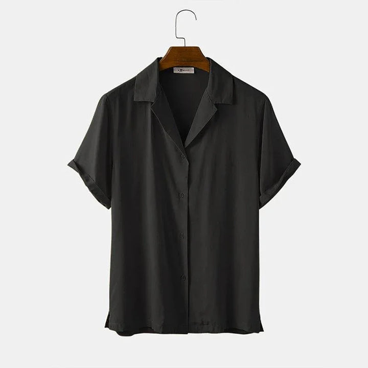 Black short-sleeve button-up shirt with collar on wooden hanger against white background