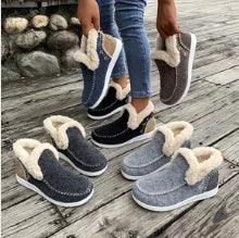 Cozy winter indoor slippers with fluffy lining in black, gray, and brown on wooden floor