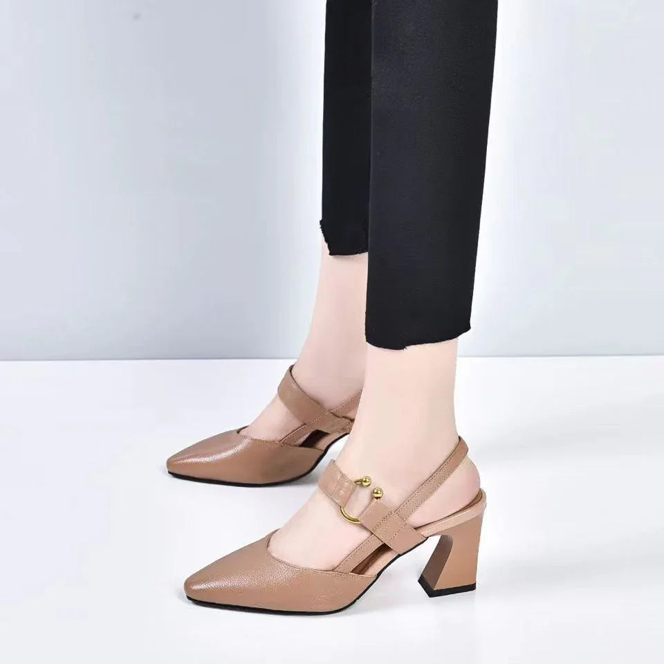 Women’s beige leather block heel slingback shoes with gold buckle detail and black pants