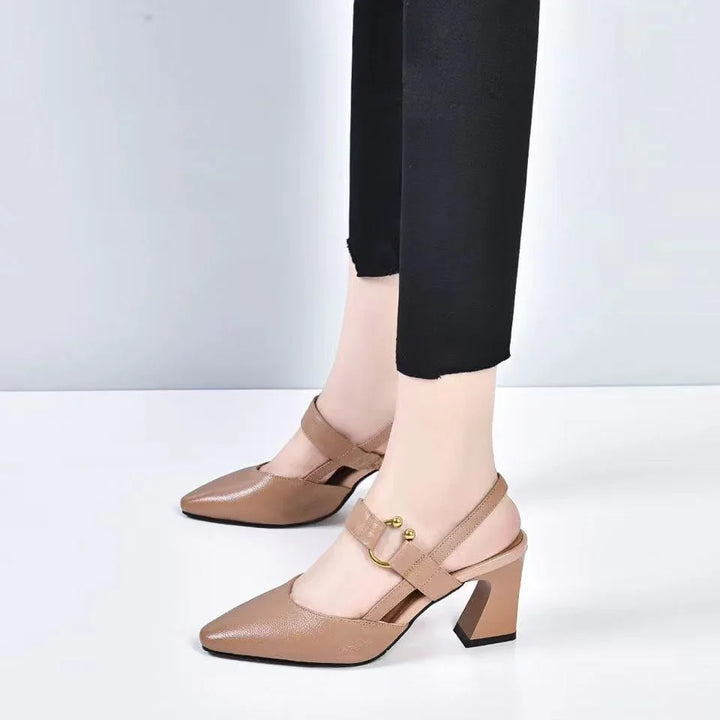 Women’s beige leather block heel slingback shoes with gold buckle detail and black pants